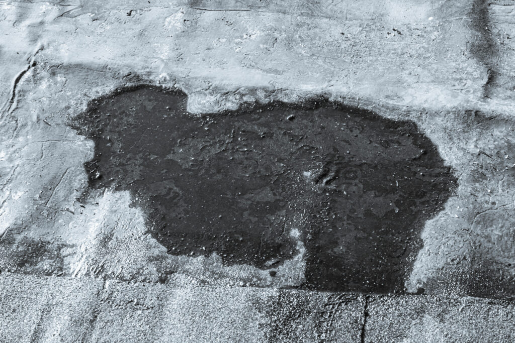 storm drain on a bitumen roof and rain puddles on an old unrepaired roof