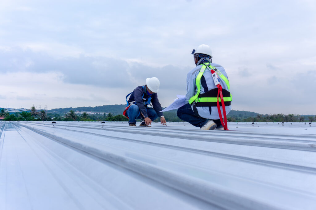 Engineers wearing full safety body harness working inspection on roof top