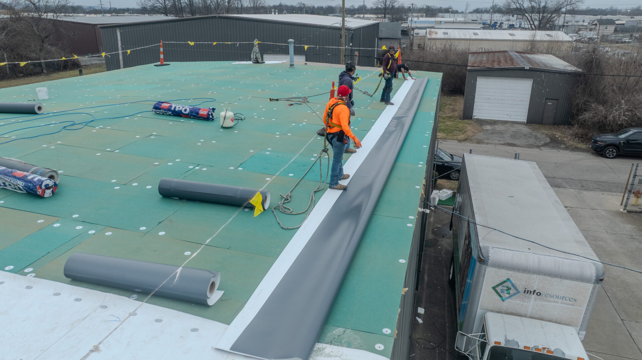 Advanced solutions workers on commercial roof