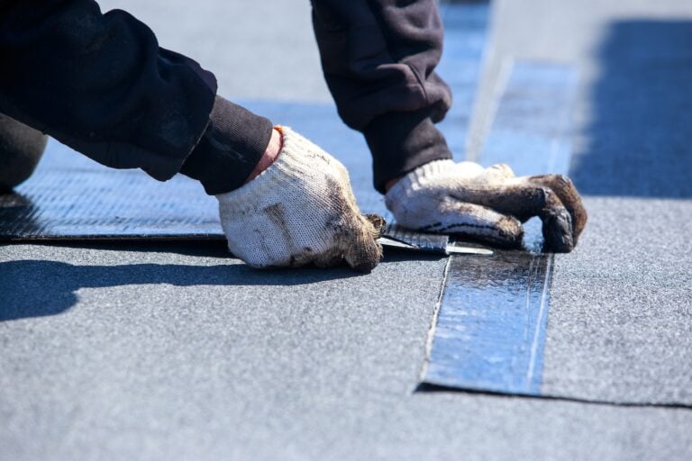 Worker cuts roofing material in the open air