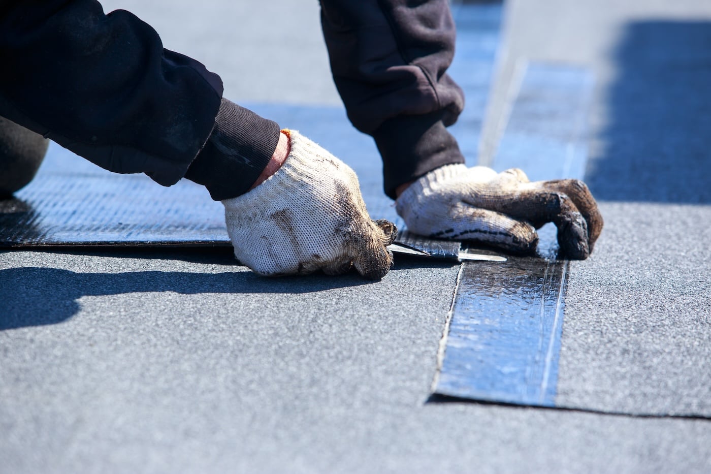 Worker cuts roofing material in the open air