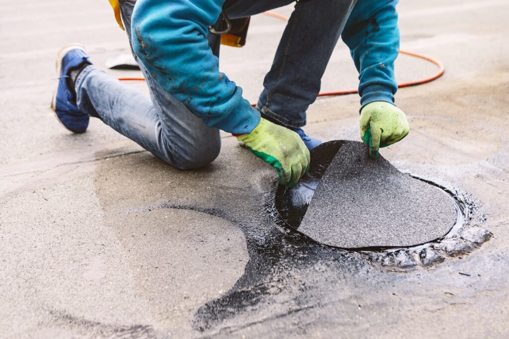 Worker repairing a damaged section of a roof