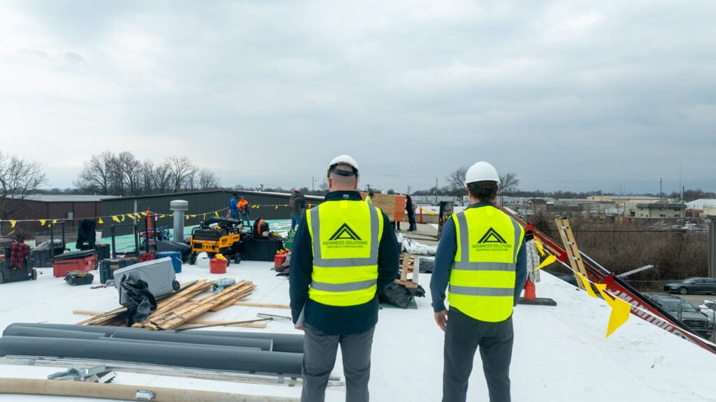 two workers on top of tpo roofing project