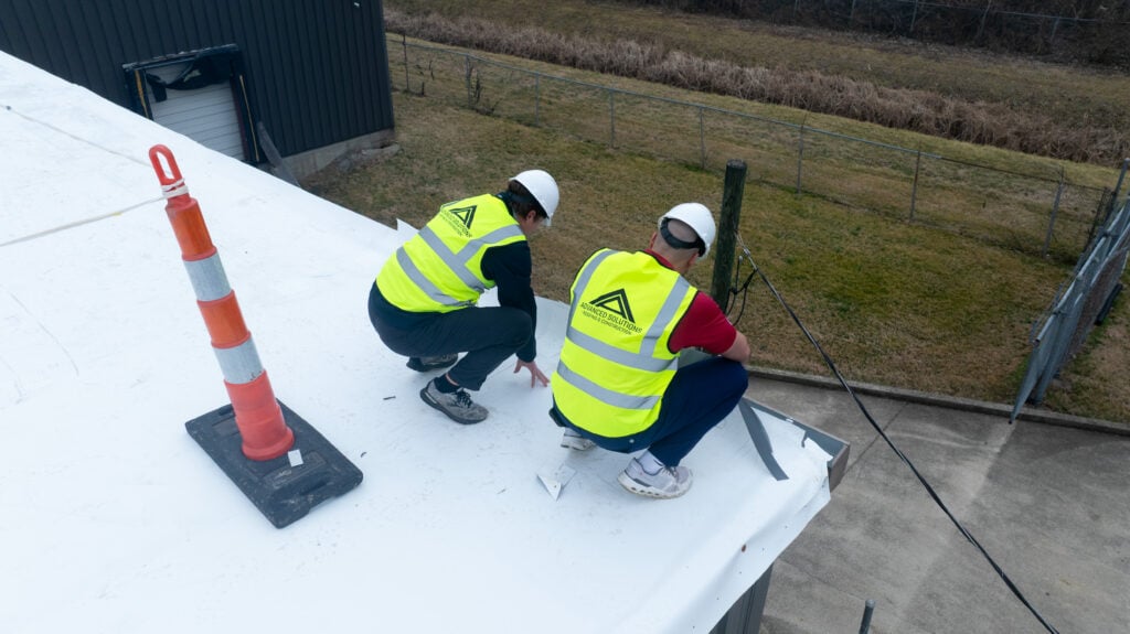 two guys inspecting tpo roof 